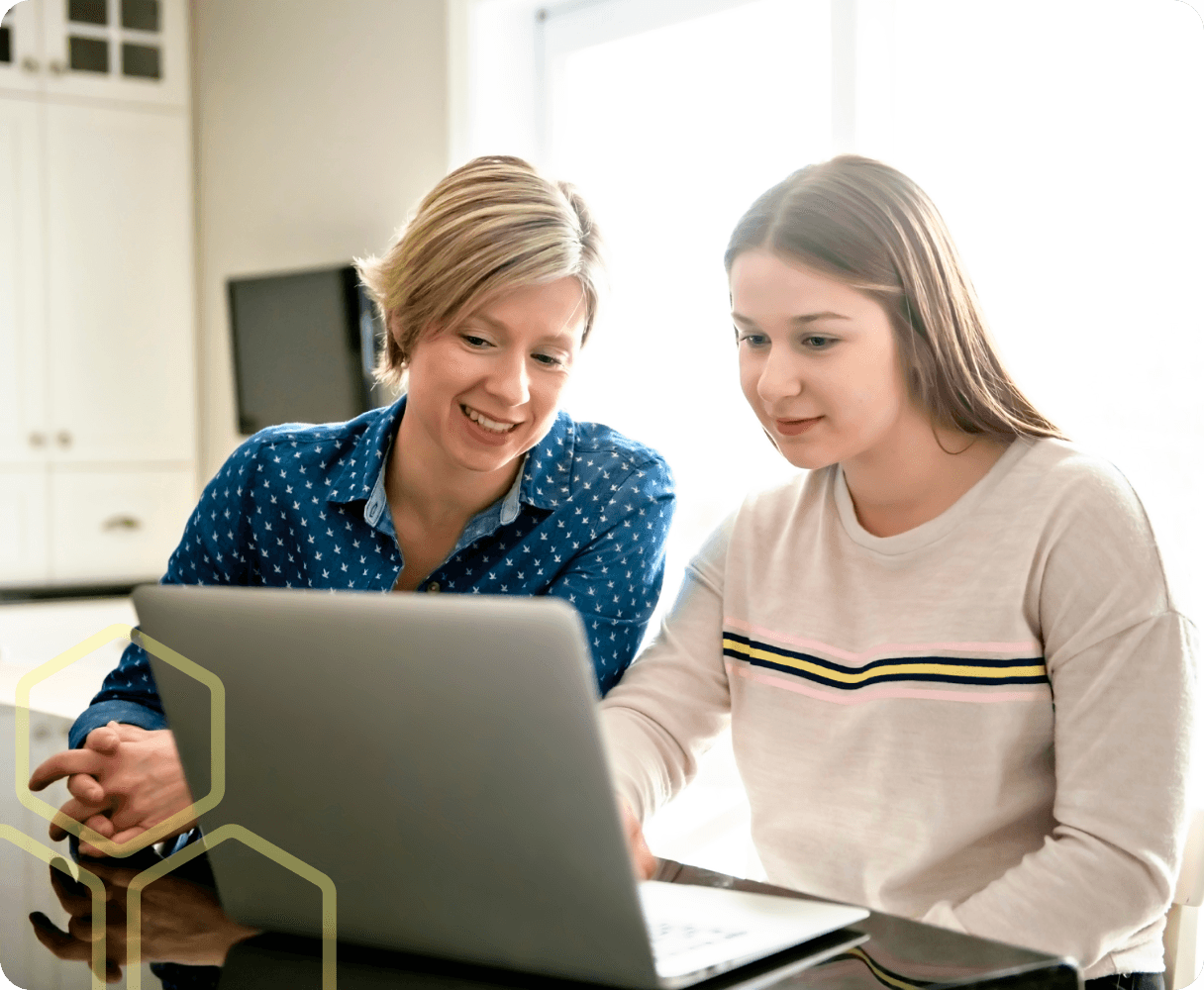Image of a teacher helping a young person on a laptop